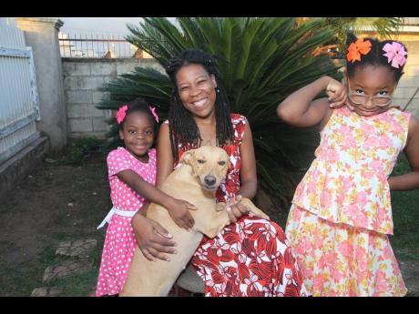 Lisa O’Connor Dennie poses for a photo with her daughters, Azania Smith (left) and Eliana Lightbourne, and the family pet. Lisa, 45, has been praying to meet her soulmate to complete her family, and possibly adding two sons.