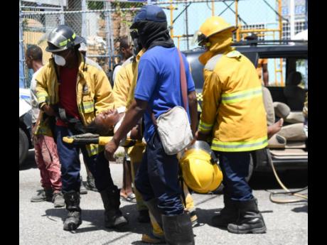 
Personnel from the Half-Way Tree Fire Department remove Semone Munroe, a femal taxi operator whose vehicle was crashed into by a Mercedez-Benz along Maxfield Avenue, St Andrew. Munroe was pinned under the steering of her car and had to be rescued by membe