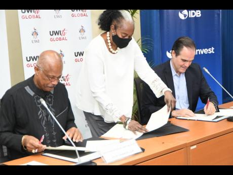 Laleta Davis Mattis (centre), university general counsel assists Professor Sir Hilary Beckles (left) vice chancellor of The University of the West Indies and Mauricio Claver-Carone, president of the Inter-American Development Bank with signing an MOU to de