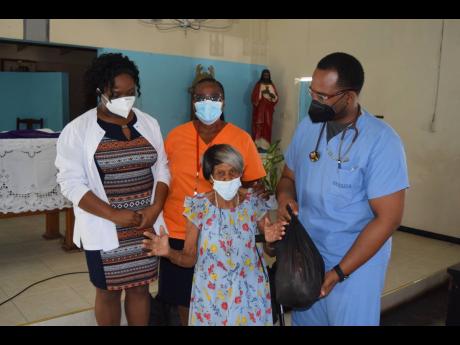 The SAJ’s bi-monthly clinic’s health team of Dr Lorenzo Crumbie (right), Nurse Samantha Ormsby (left) and Nurse Deanmarie White (centre) share a light moment with an appreciative Othilda Brown.