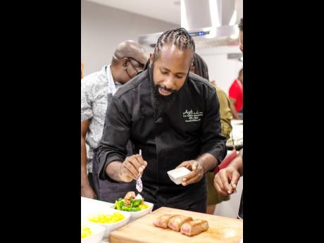 Celebrity Chef Oji Jaja adds his finishing touch to the pan-seared tuna dish prepared by media practitioners at the Jamaica Food and Drink Cooking Experience, hosted by Digicel Business and Johnnie Walker last Friday.