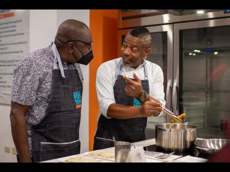 Nationwide 90FM’s Rodney Campbell (right) appears to be giving cooking tips to his boss, Chief Executive Officer Cliff Hughes.