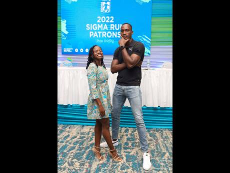 Olympians Megan Tapper and Hansle Parchment strike a pose following the announcement of their patronage for the 2022 Sagicor Sigma Run. 