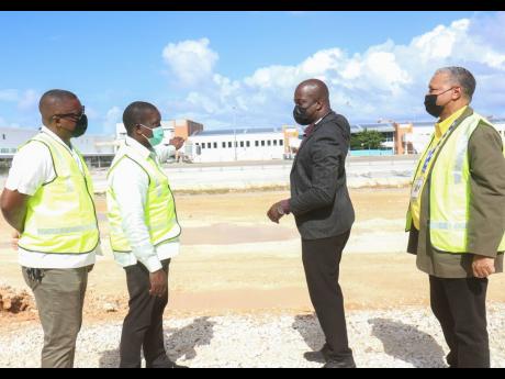 Robert Montague (second left), minister of transport and mining, and Shane Munroe (second right), CEO of MBJ Airports Limited, engage in conversation during a tour of Sangster International Airport in Montego Bay on Thursday. They are flanked by St James C