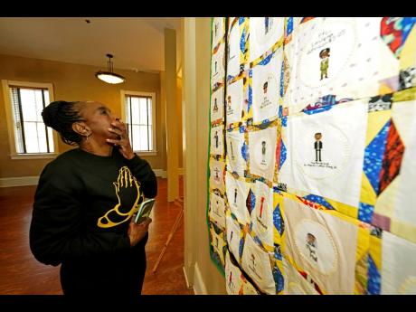 
Gloria Green-McCray, the younger sister of James Earl Green, who along with Phillip Lafayette Gibbs were killed by Mississippi Highway Patrolmen in 1970 on the campus of Jackson State, reacts to viewing a section of one of two hand crafted quilts adorned 