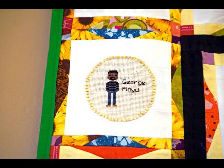 A portrait of the late George Floyd is among the 116 cross-stitched images adorning one of two hand crafted quilts honouring African Americans who lost their lives to racial violence, as part of the Stitch Their Name Memorial Project, on display at the Mar