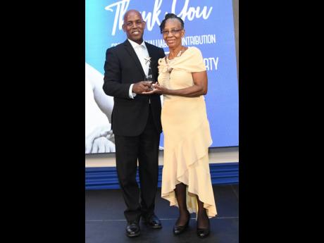 President of JCCUL Lambert Johnson presents the long service award for 35 years to Marjorie Carty.