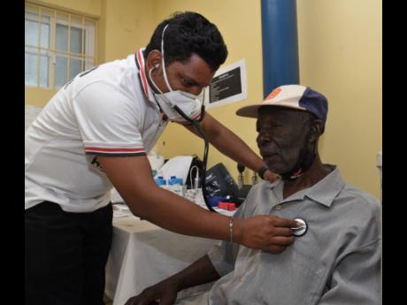 Dr Nagendra Babu Chandolu (left) checks the heart rate of Raphael Tyrell during a medical camp hosted by the Indian High Commission at the Good Samaritan Inn in Kingston on Sunday.  