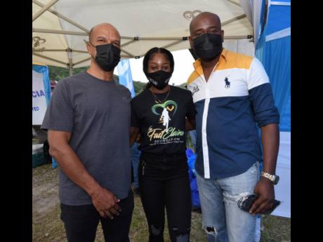 Elaine Thompson Herah (centre), along with Peter Bunting (left), former member of parliament, Manchester Central, and Mario Mitchell, councillor for the Bellefield division, during a visit to the community last Saturday.  Thompson Herah recently gave back 