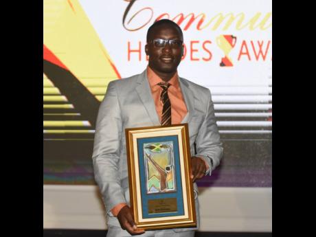 Demar Demontagnac, a marketing student at the College of Agriculture, Science and Education, poses with his latest award as he was on Tuesday honoured as one of 50 Sagicor Community Heroes at a ceremony at The Jamaica Pegasus hotel in New Kingston.