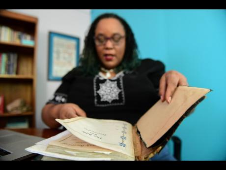 Dr Deborah Hickling Gordon shows off some family heirlooms during an interview yesterday. Among the historical items are four Bibles belonging to the family matriarchs.