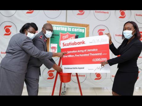 Divisional Commander for the Eastern Jamaica Division, Major Oral Morris (second left),  and Major Marcia Morris, accept Scotiabank’s contribution of $1.5 million from Michelle Wright, chief financial officer, Scotiabank Jamaica, during a presentation ce