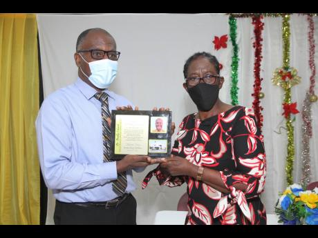 Dr Bradley Edwards, senior medical officer at the May Pen Hospital in Clarendon, accepts a token of gratitude for his service from a grateful Barbara Riley Williams.