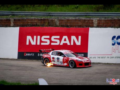 Mark Viera’s RX8 spits fire as it approaches corner three at Dover.