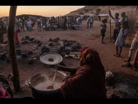 In this November 2020 photo Sudanese women volunteer to cook for Tigray people who fled the conflict in Ethiopia’s Tigray region, at Umm Rakouba refugee camp in Qadarif, eastern Sudan.