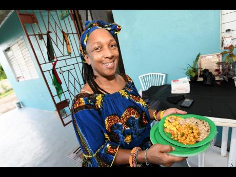 Sophia Newman-Walsh shows off a plate of food consumed during a traditional Kwanza celebration in Oracabessa, 
St Mary.