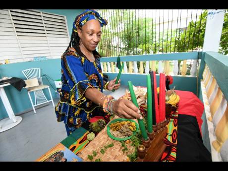 Sophia Walsh-Newman affixes the candles that form part of the customary Kwanza celebrations in Oracabessa, St Mary, on December 23.