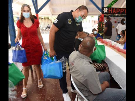 Health and Wellness Minister Dr Christopher Tufton (second left) and Dr Diana Thorburn (left), chairman, Bellevue Hospital, hand out care packages to patients during the annual patients' banquet held last Wednesday.