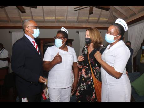 Cornwall Regional Hospital’s Senior Medical Officer Dr Derek Harvey (left) chats with nurses Claudette Taylor and Melissa Winder, as well as Kathryn May, vice-chairman of Doctor’s Cave Bathing Club, at the attraction’s ‘Honouring Our Nurses’ cere