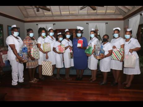 Matron Gillian Ledgister (in blue), director of nursing at the Cornwall Regional Hospital, is flanked by her nurses after being awarded by the Doctor’s Cave Bathing Club on Wednesday, December 22. 