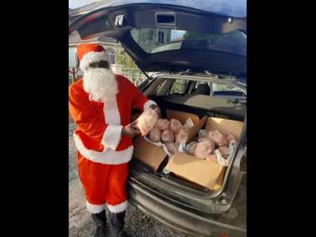 A member of the James and Friends Education Programme dons a Santa suit with chickens for delivery.