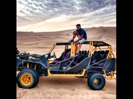 Andre Whittaker takes a snap on top of a dune buggy in Huacachina, a village in Peru.  