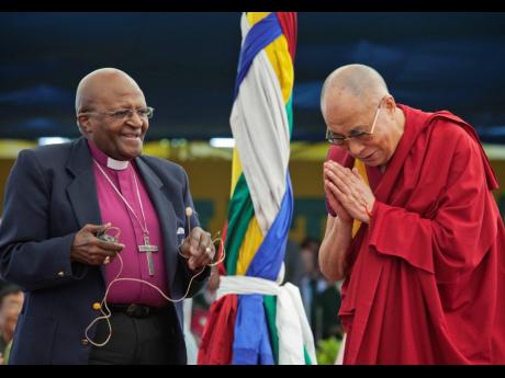Archbishop Desmond Tutu, left, holds a microphone as Tibetan spiritual leader the Dalai Lama gestures, as they interact with children at the Tibetan Children’s Village School in Dharamsala, India, in 2015. 