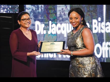 Chief Medical Officer Dr Jacquiline Bisasor-McKenzie (left) accepts the RJRGLEANER Honour Award for Public Service from Gleaner Editor-in-Chief Kaymar Jordan.