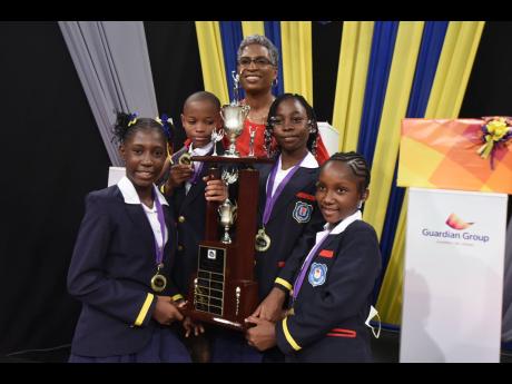 Claire Grant, general manager of Television Jamaica, celebrates with the victorious Friendship Primary team after they won the 2021 staging of TVJ’s Junior Schools’ Challenge Quiz. The team members are (from left) Alaina Smith, Teon Hughes, Damonesh Cl