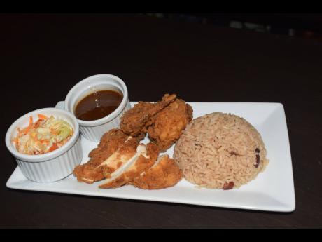 Traditional rice and peas and fried chicken served with raw vegetables from RKK Restaurant and Catering. 