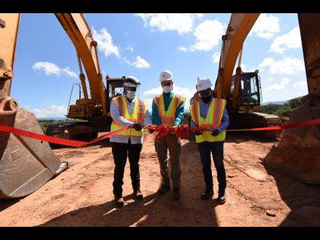 From left: Mining Minister Robert Montague cuts the ribbon for the effluent holding pond expansion project along with Sergey Kostyuk, Windalco country manager, and Stevie Barnett, general manager, Jamaica Bauxite Institute, during an launch on site at Wind