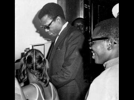 
Actor Sidney Poitier obliges an eager fan by signing an autograph following his arrival at the Sheraton-Kingston Hotel in Jamaica, in 1968.
