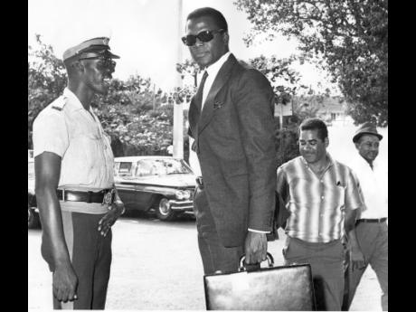 
Known for his handsome, flawless face, intense stare, and disciplined style, Sidney Poitier is the picture of class as he stands with a police officer during his weekend visit to Jamaica in 1968.
