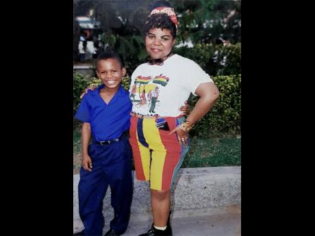 Wearing his Jamaica College uniform, a young Kevin Smith poses for a photo with his mother.