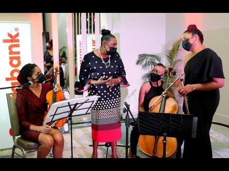 Olivia ‘Babsy’ Grange (second left), minister of culture, gender, entertainment and sport, spends a moment with members of the Practical Trio (from left), Truddi Clarke, Emily Ruth, and Gabrielle Clarke, who performed an inspired set during the launch 