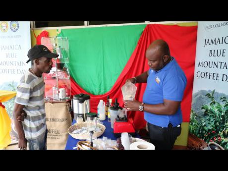 Nicholas Carrole, compliance officer, serves a member of staff a Jamaica Blue Mountain Coffee smoothie at the Jamaica Agricultural Commodities Regulatory Authority during the agency’s observance of Jamaica Blue Mountian Coffee Day on Friday. 