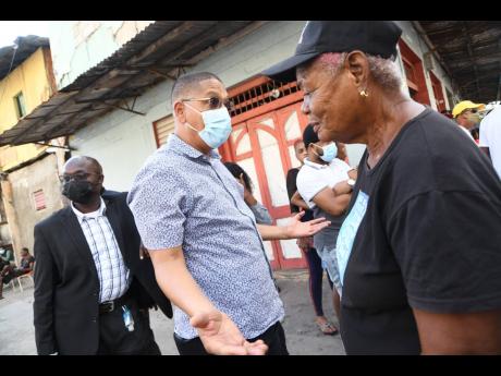 Donovan Williams, (centre) member of parliament for Kingston Central speaks with a resident at a meeting organised by the police and stakeholders with residents of Tel Aviv in Southside Central Kingston on Friday. 