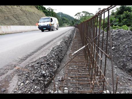 A motor vehicle traverses a section of the Broadgate to Agualta Vale roadway in St Mary that is still under construction. 