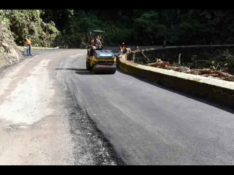 A section of the roadway between Broadgate and Devon Pen along the Junction main road, St Mary, being paved with asphalt.