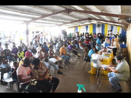 Scores of persons wait patiently to be vaccinated at the Central High School in May Pen, Clarendon, on December 8. 