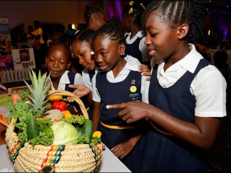 Students delighted over a colourful basket of fruits and vegetables.