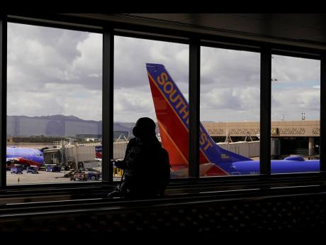 A passenger walks pass a Southwest Airlines plane at Sky Harbor International Airport in Phoenix on March 26, 2021. 