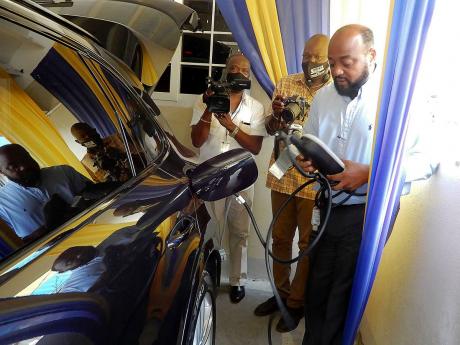 Then St Ann Mayor Michael Belnavis shows how his Porsche Cayenne hybrid motor car is charged electrically in June 2020. More than a year after Belnavis called critics “bad-mind”, CEO Rovel Morris has been recommended for sanctions for his role in the s