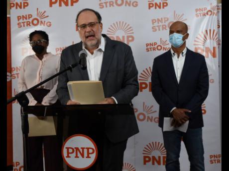 Mark Golding (centre), Opposition leader and president of the People's National Party, addresses the media during a press conference on the economy, national security, health and education.