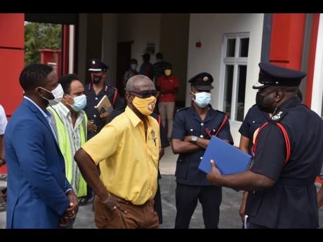 Jamaica Fire Brigade Deputy Commissioner  Kevin Haughton (right) speaks about on the occupational health and safety plans for the Montego Bay Fire Station during a tour of the almost-completed facility yesterday. Among those listening are Montego Bay Deput