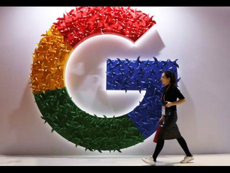 A woman walks past the logo for Google at the China International Import Expo in Shanghai in Novmber 2018.