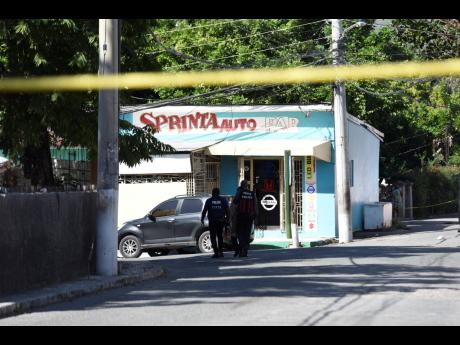 Police cordon off a section of Whitehall Avenue in St Andrew, where businessman Craig ‘Sprinta’ Gooden was shot and killed yesterday morning as he arrived to open his auto parts store.