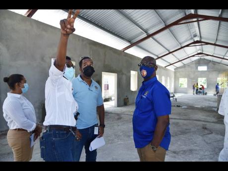 Ava Murdock (second left), superintendent for the Roads and Works department at the Westmoreland Municipal Corporation summoned the attention of Wray Nelson (second right), structural engineer in the Ministry of Local Government and Rural Development, and 