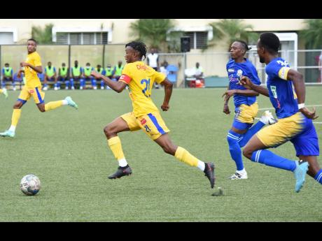 
Orlando Harding (left) from Harbour View attempts to outrun the Molynes United pair of Rashawn Livingston (centre) and Damion Thomas during their JPL football match at the UWI-JFF Captain Horace Burrell Centre of Excellence on Tuesday.
