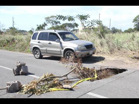 Some motorist travelling along the Lionel Town main road ignore the detour sign  and cross the drain which collapsed over a week ago.